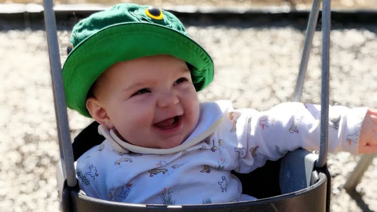 Baby staying sun-safe in a swing.