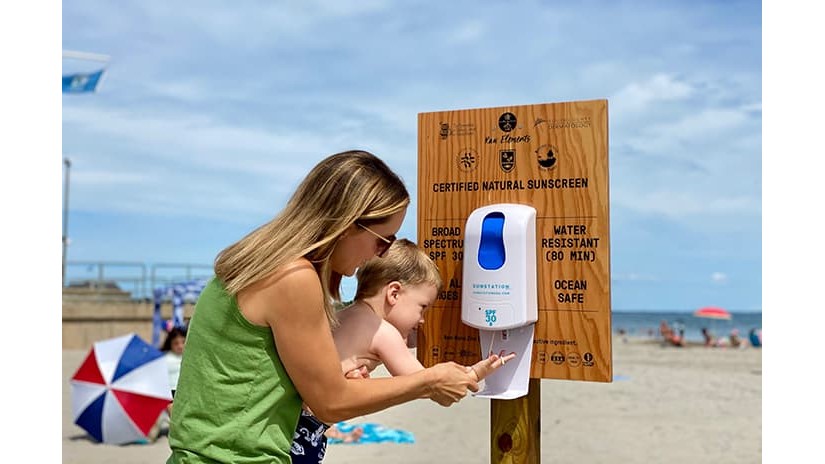 Rhode Island Dispenser Mother Child Terri Flori helps her son Kai apply sunscreen from a dispenser at Scarborough State Beach in Narragansett, Rhode Island.