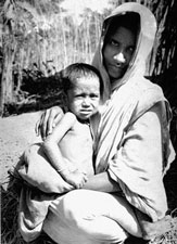 Rahima Banu A Bangladeshi woman holds a small child in her arms.