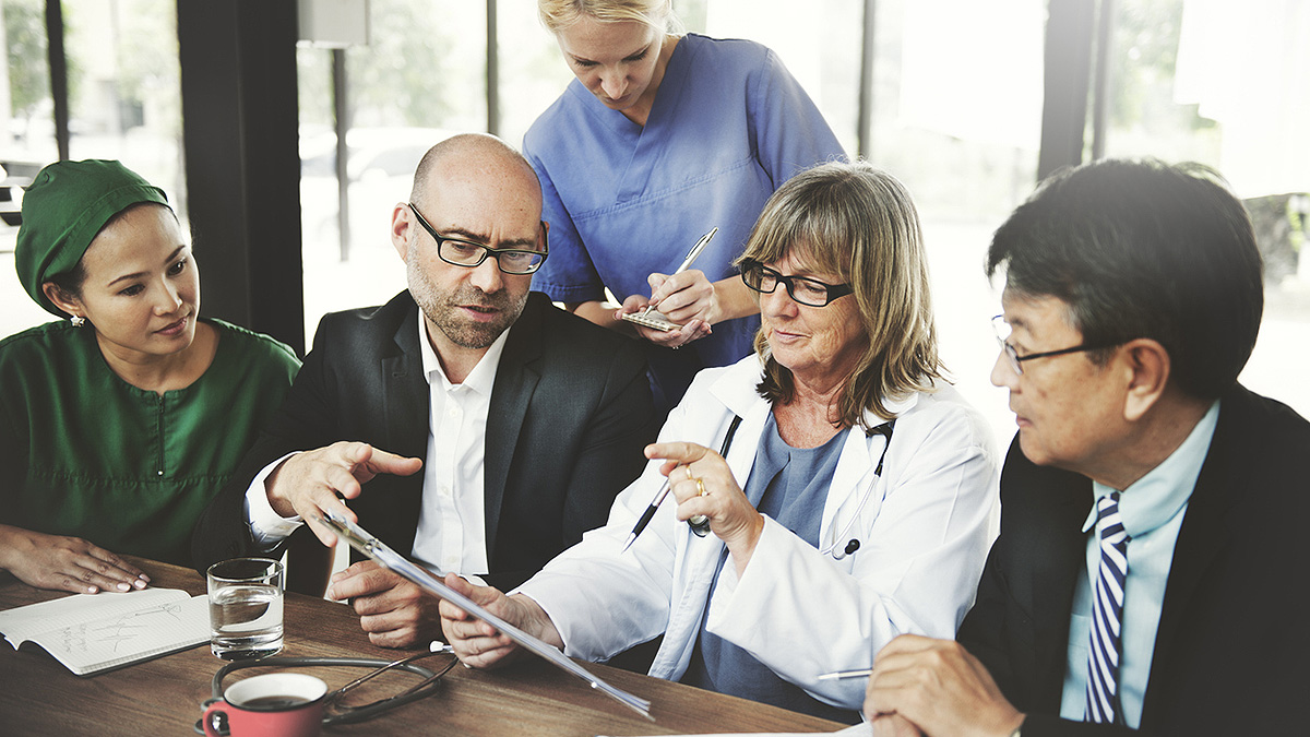 Medical Collaboration Medical and other community representatives collaborating at a conference table.