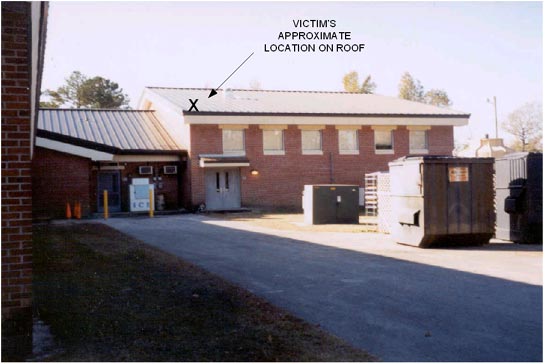 full200303b Foto 1. Esta foto muestra el techo de la escuela primaria en donde se estaba realizando el trabajo. La X marca el lugar aproximado donde estaba la víctima, sobre el techo de pendiente baja, antes de su caída.