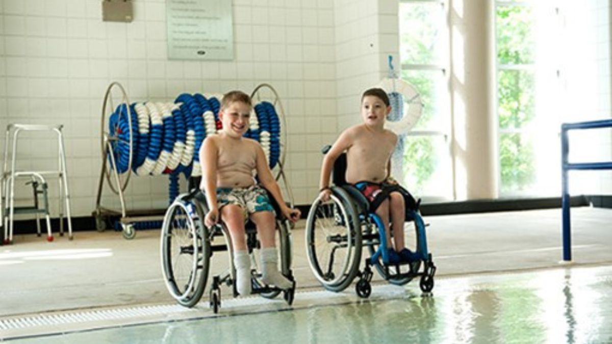 Kids with spina bifida Kids with spina bifida smiling near an indoor pool
