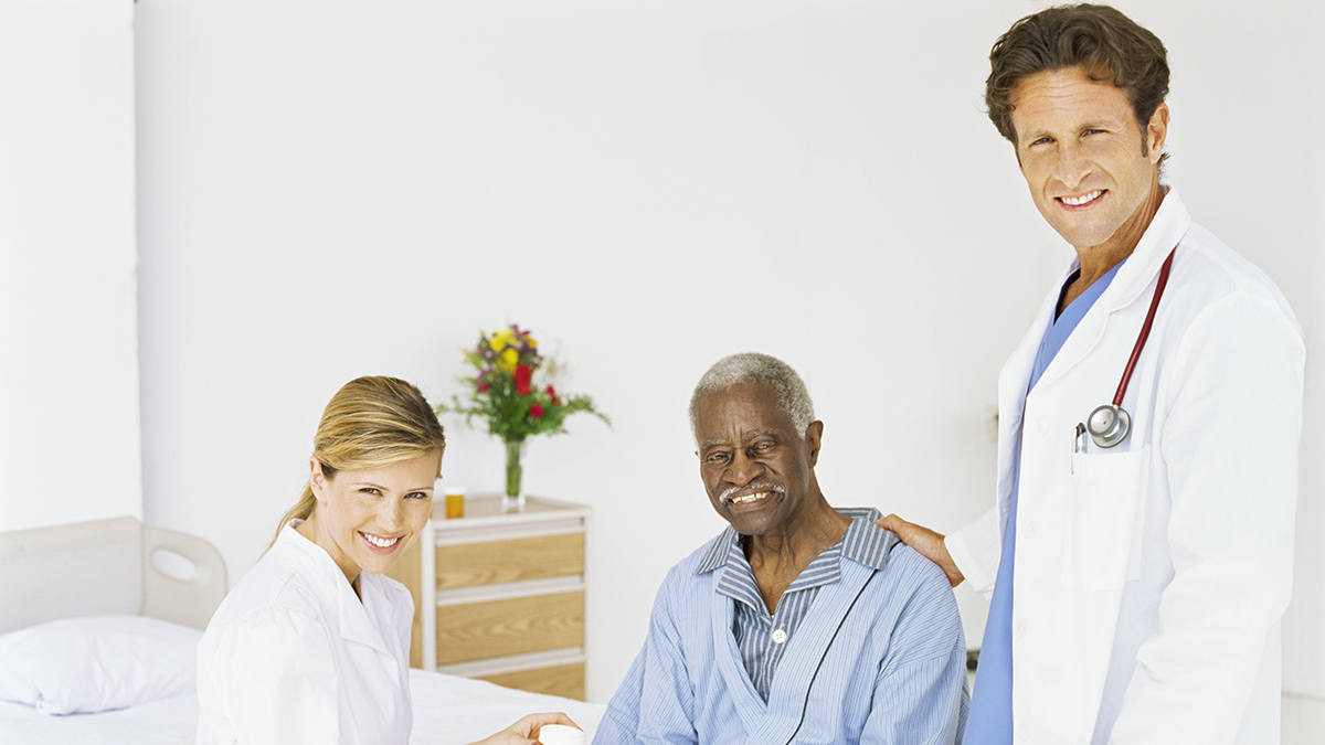 Doctor and nurse with older adult patient Doctor and nurse with older adult male patient