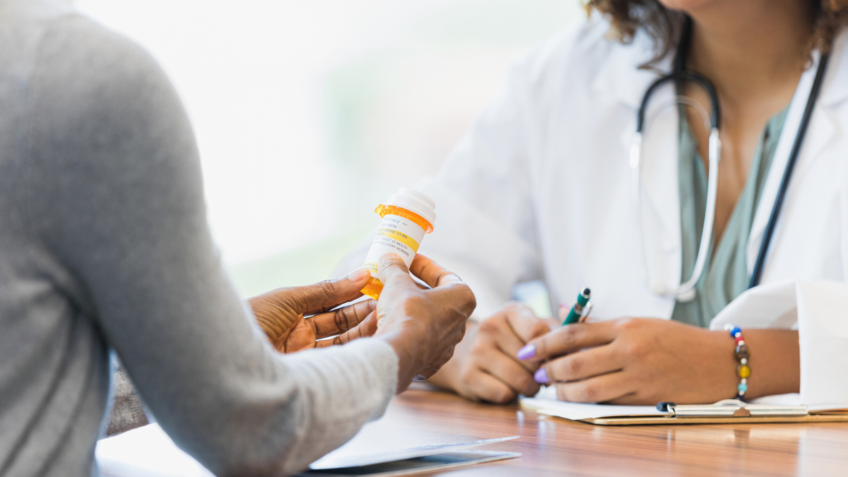 Doctor giving a prescription to a patient. Doctor giving a prescription to a patient.
