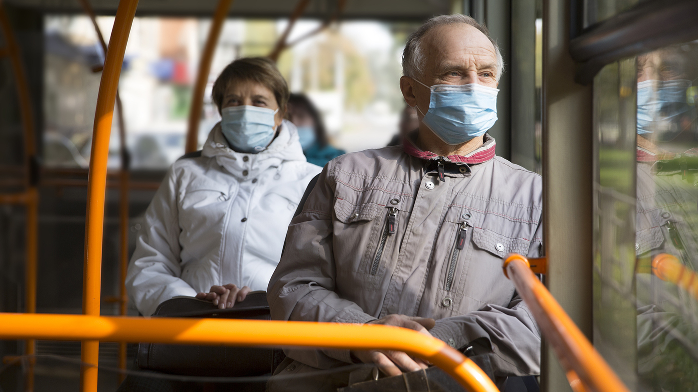 Senior man wearing medical face mask sitting in the bus