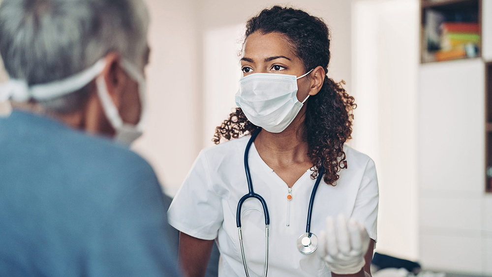 Female doctor talking with a senior patient Female doctor talking with a senior patient. Both people are wearing protective face masks