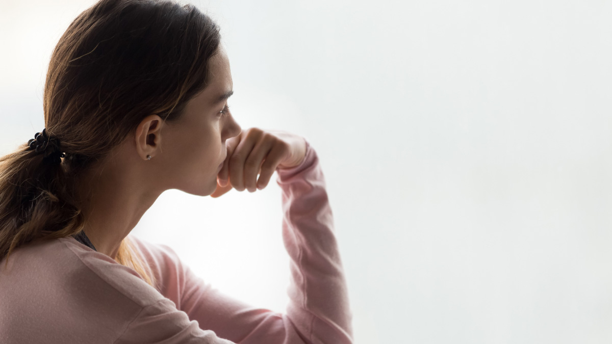 Mujer joven que parece estar triste mirando hacia la distancia. Mujer joven que parece estar triste mirando hacia la distancia.