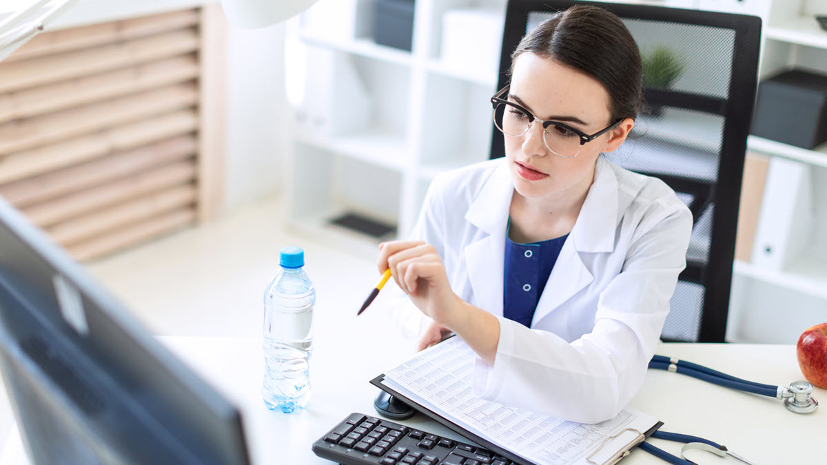 Health care provider seated at computer Health care provider working on a computer.