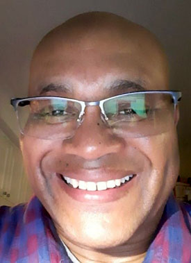 Verden Douglas Headshot of Verden Douglas wearing glasses and a checkered shirt.