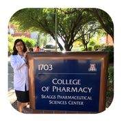 Personal Stories Thu College of Pharmacy Thu, a tuberculosis survivor, next to the sign for her College of Pharmacy program
