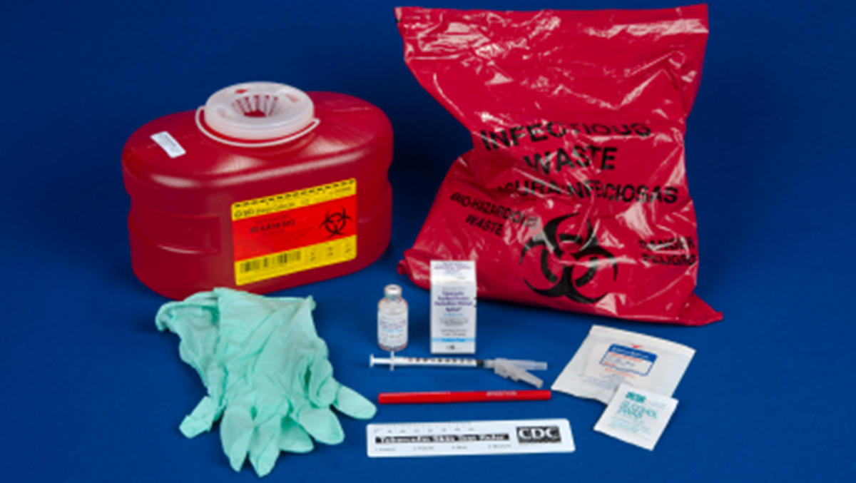 -- title missing -- Supplies for administering and reading a TB skin test, including gloves, needle, tuberculin, sharps container, and ruler.