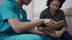 Provider Female Patient Reviewing Document A health care provider and female patient review a document together