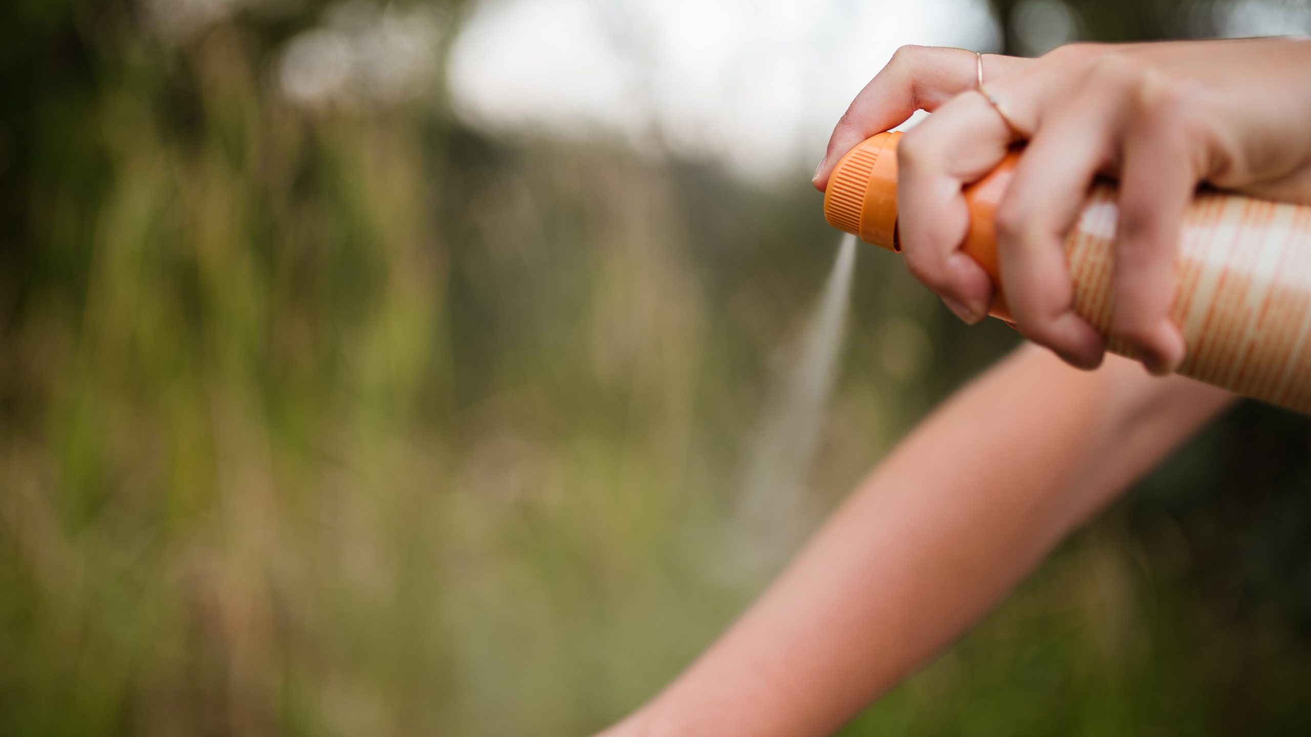 Repellent arm 16x9 Person spraying insect repellent onto their arm.