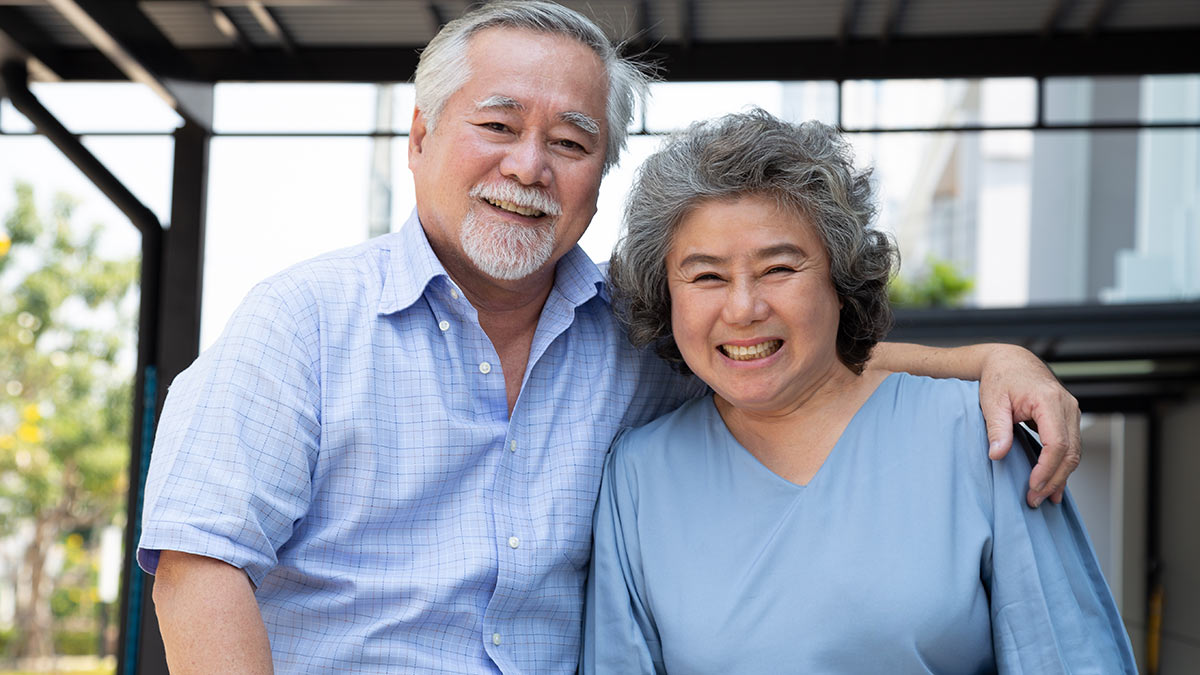 AAPI Asian Couple Man with his arm around his wife