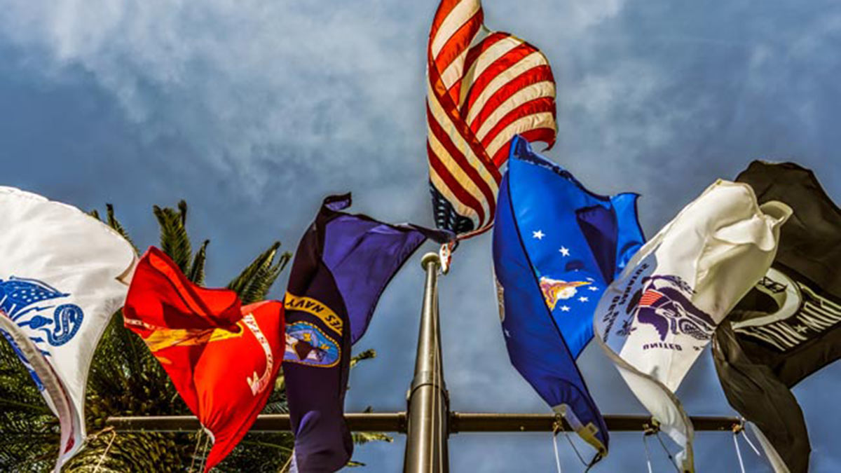 Military Appreciation Month United States flag surrounded by U.S. military-related flags.