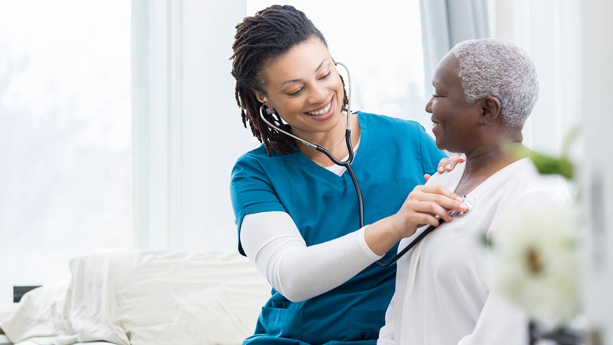 cdc-osh-np-and-patient Doctor using a stethoscope to check patient's vitals.