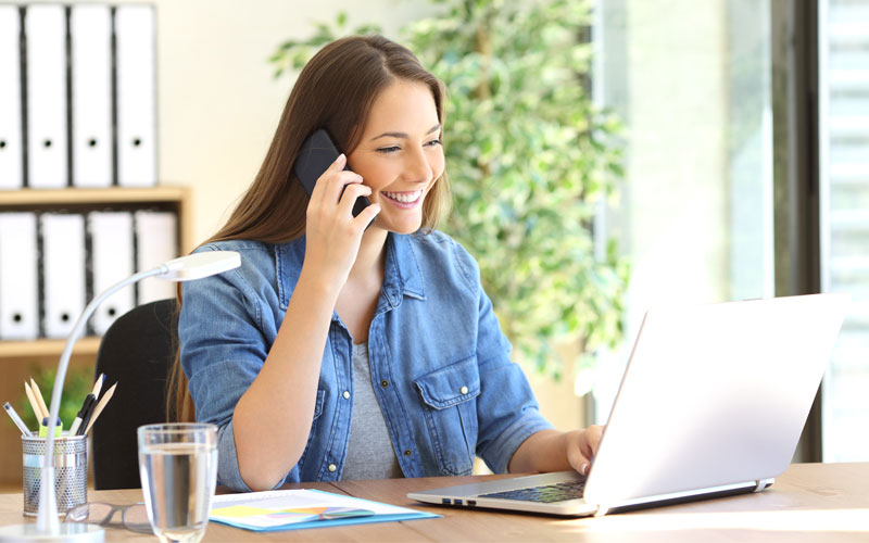 quitline-quest10-2 How do I know using a quitline will help? Happy woman on phone looking at her laptop.