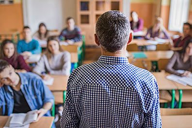 youth-factsheet-image4 Teacher speaking to high school students.
