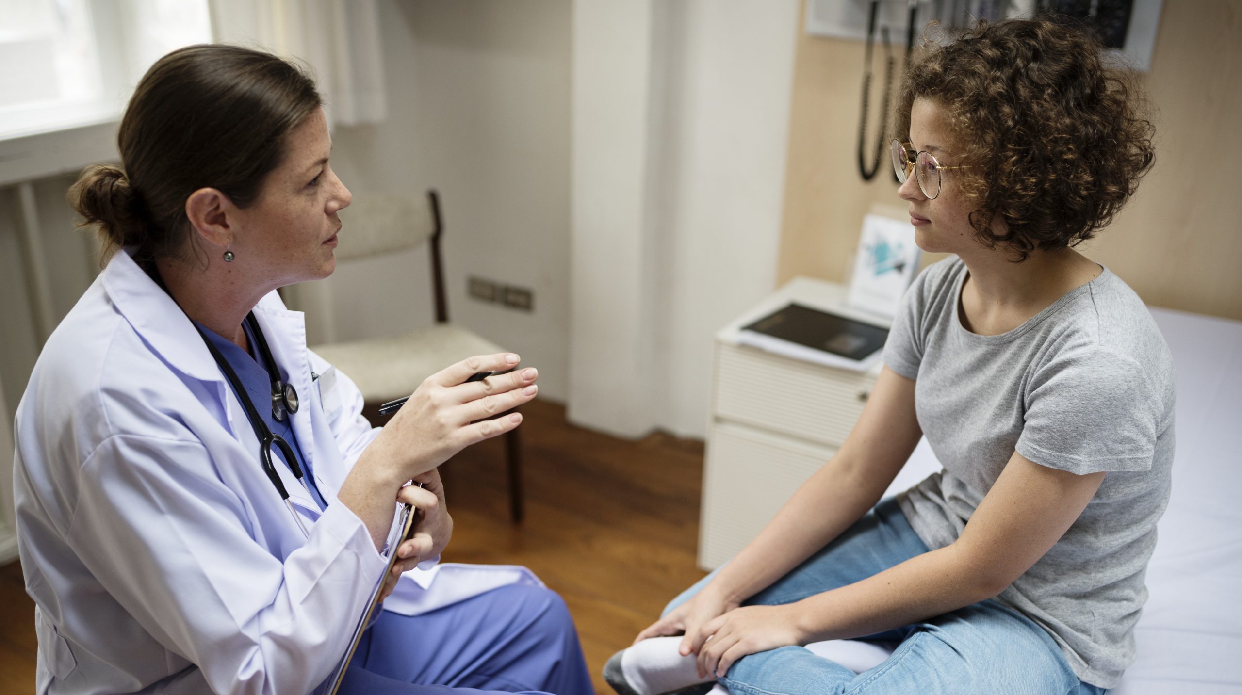HCP and teen in clinic setting Health care provider talks with teen about e-cigarettes.