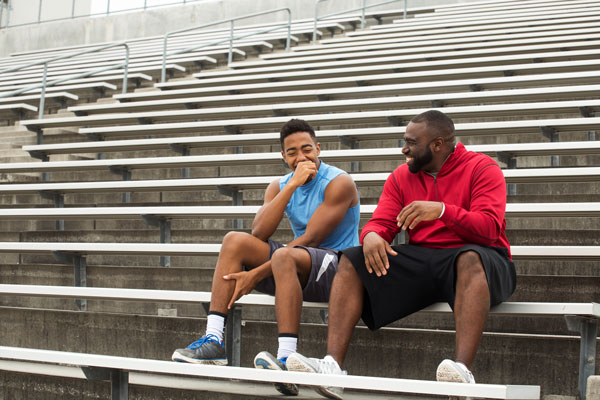 e-cigarette features 2024 Father and son sitting on the stadium bleachers talking