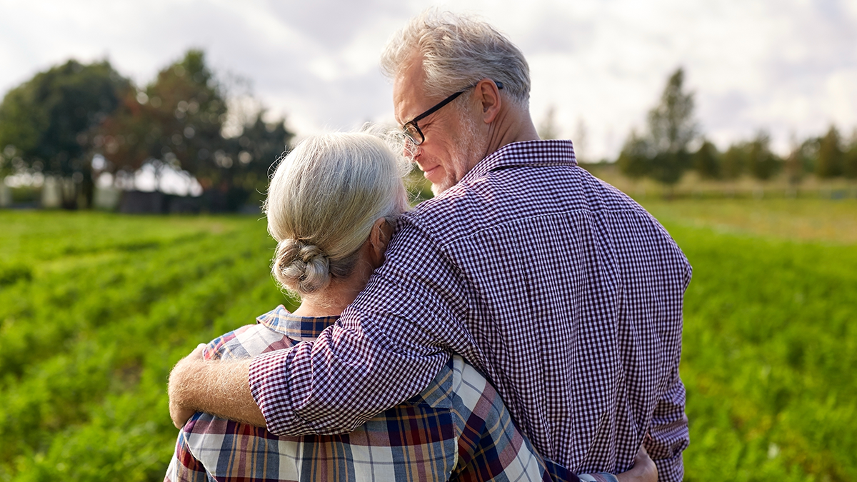 Couple in field Couple in field with arms around each other