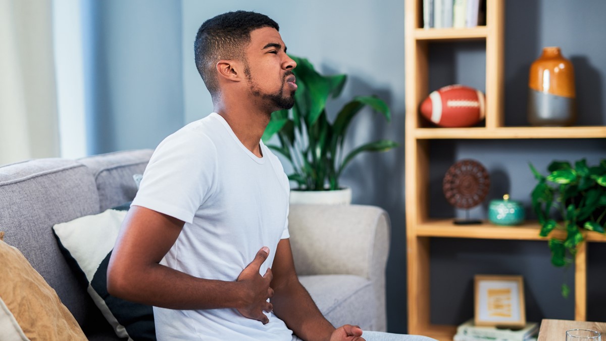 A man holds his stomach owing to pain
