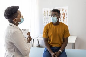 Reasons to vaccinate 1 A young man listens to a healthcare provider at a clinic.