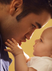 father and baby Baby touching father's face as they stare at each other.