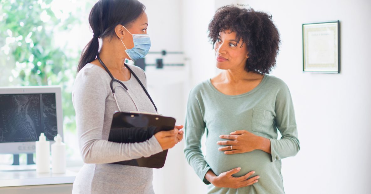Doctor speaking to pregnant women in healthcare setting