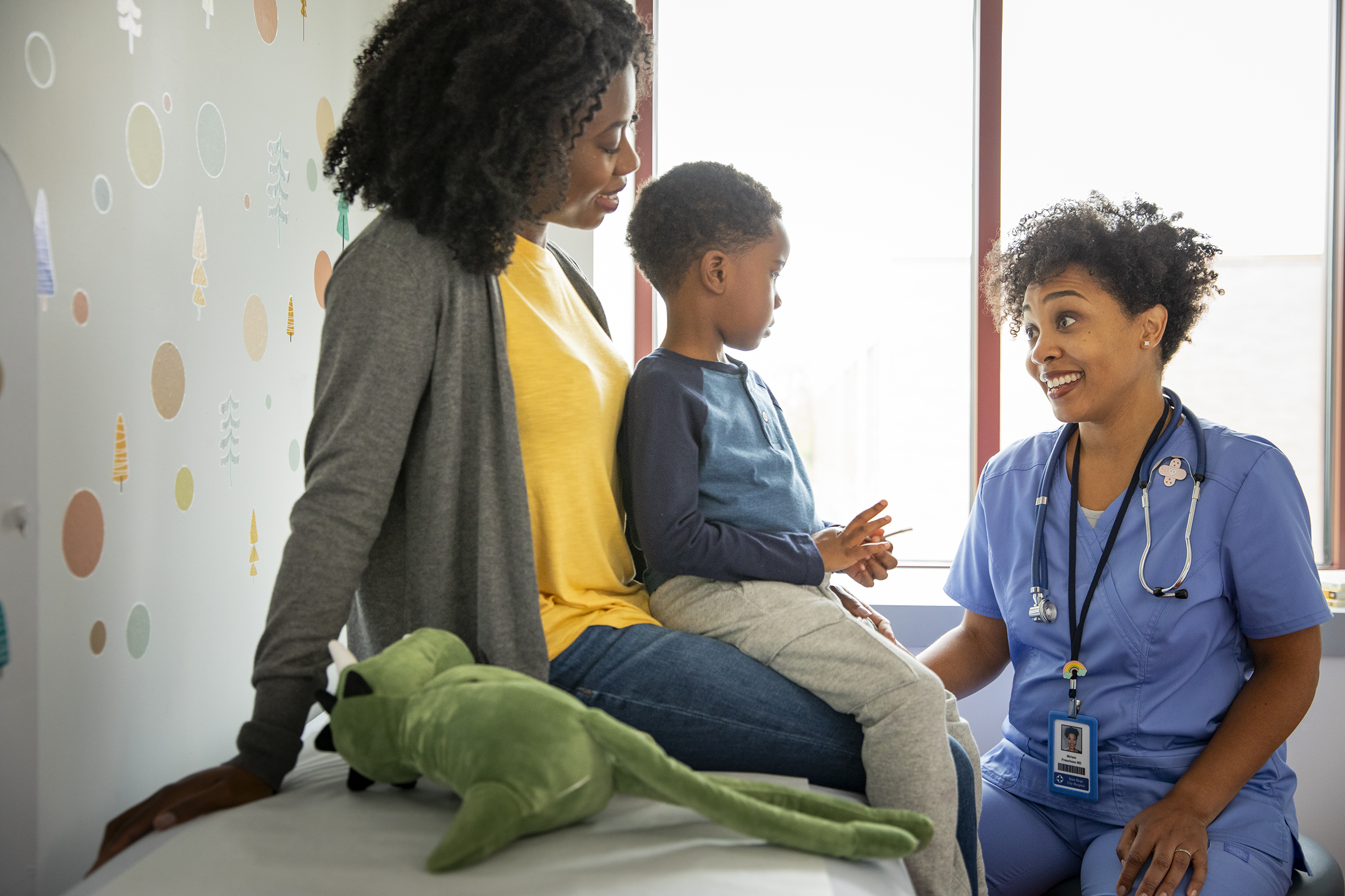 Pediatric patient and parent with healthcare provider talking Pediatric patient and parent talking to healthcare provider in a medical office.