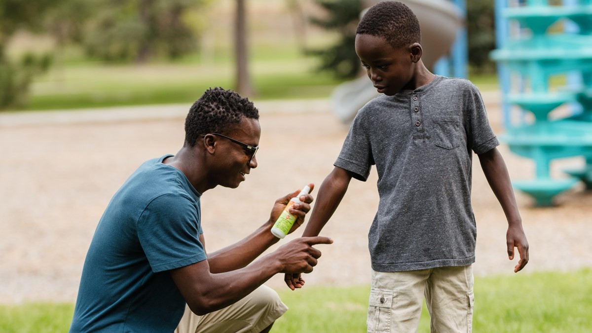 Adult applying repellent An adult applying insect repellent to a child