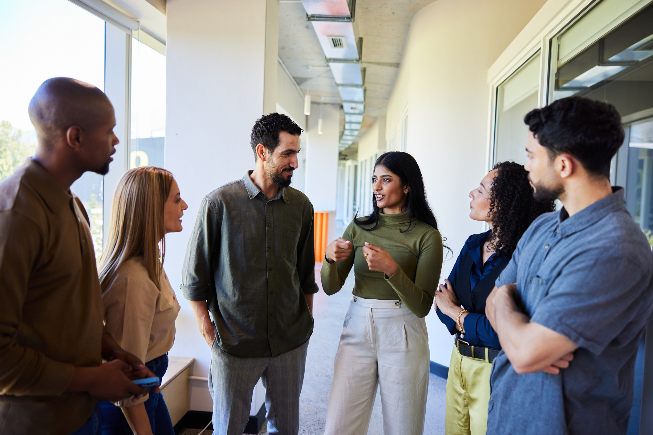 Group of diverse colleagues talking in an office hallway Group of diverse colleagues talking in an office hallway