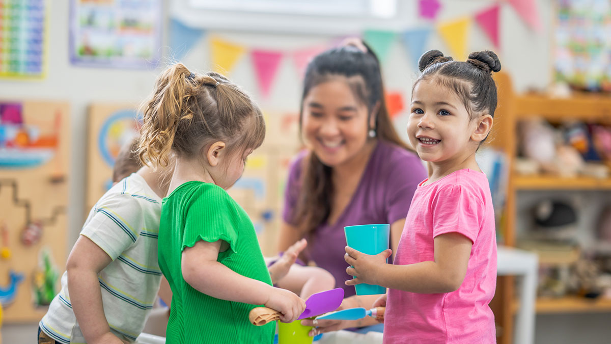 Early care provider working with children An early care provider working with children at the activity table