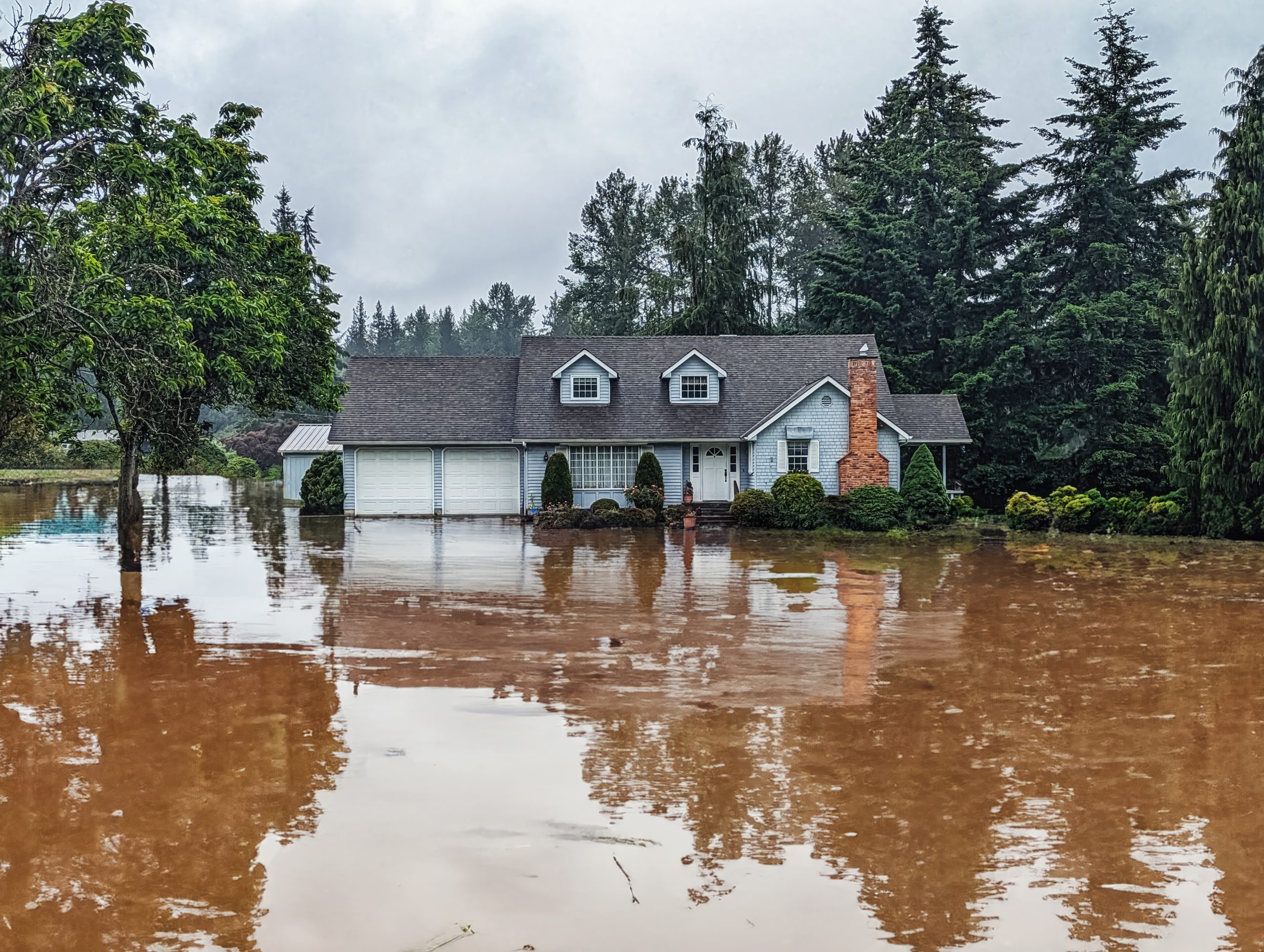 Flooding around a house in rural area Deep floodwater around a house in a rural area after a natural disaster.