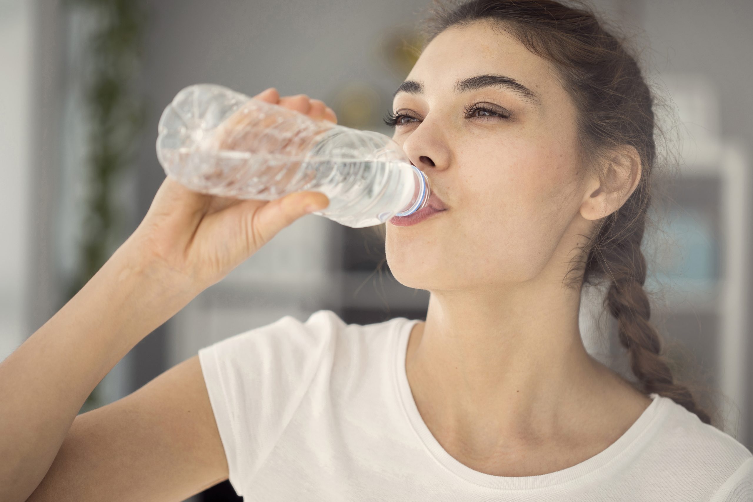 Mujer bebiendo agua embotellada Mujer bebiendo agua embotellada