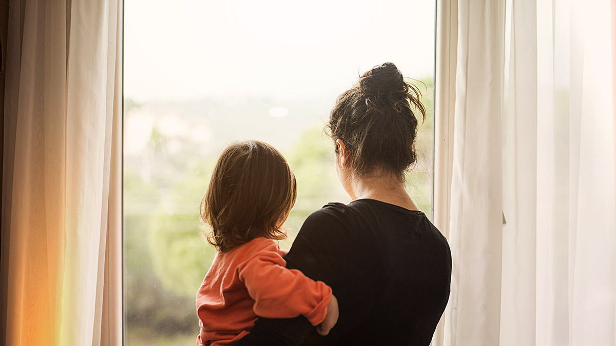 motherdaughter window Mother carrying child and staring out the window.