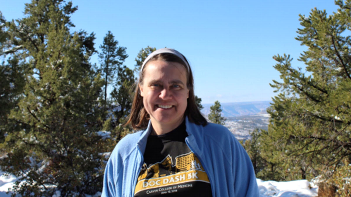Cecilia Norris TB Champion Cecilia Norris wearing a blue jacket smiling outside in front of trees and snowy mountains