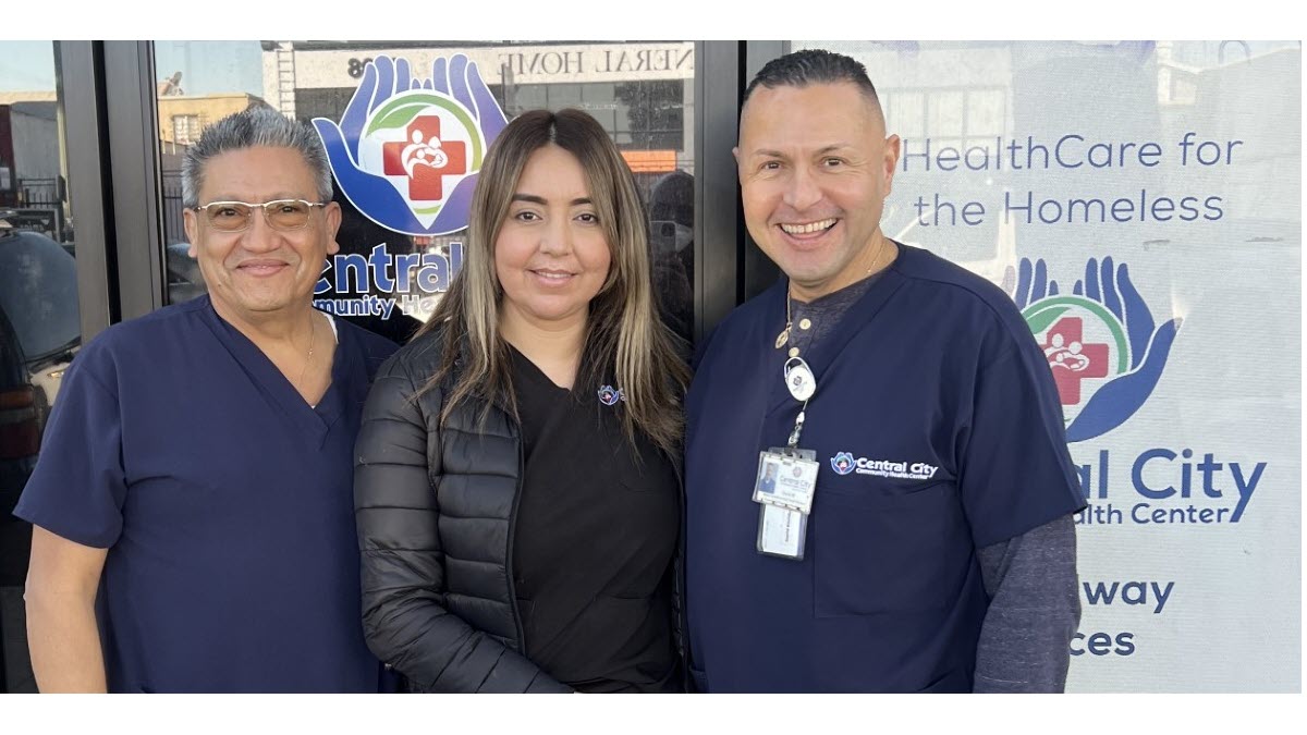 Central City Community Health Center 3 Outreach Team workers at Central City smiling and wearing scrubs outside of a health clinic