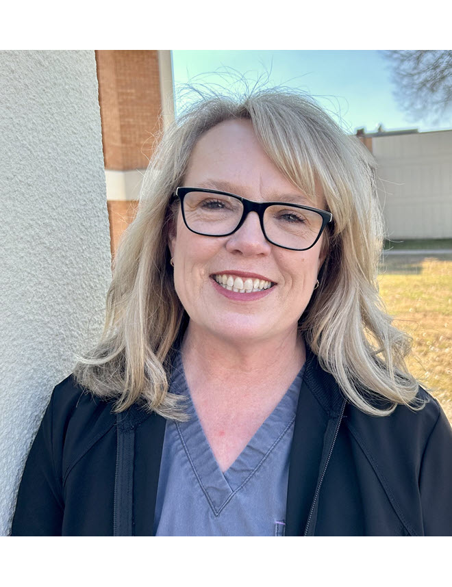 Teresa Plummer Teresa Plummer smiling wearing scrubs and a blue jacket