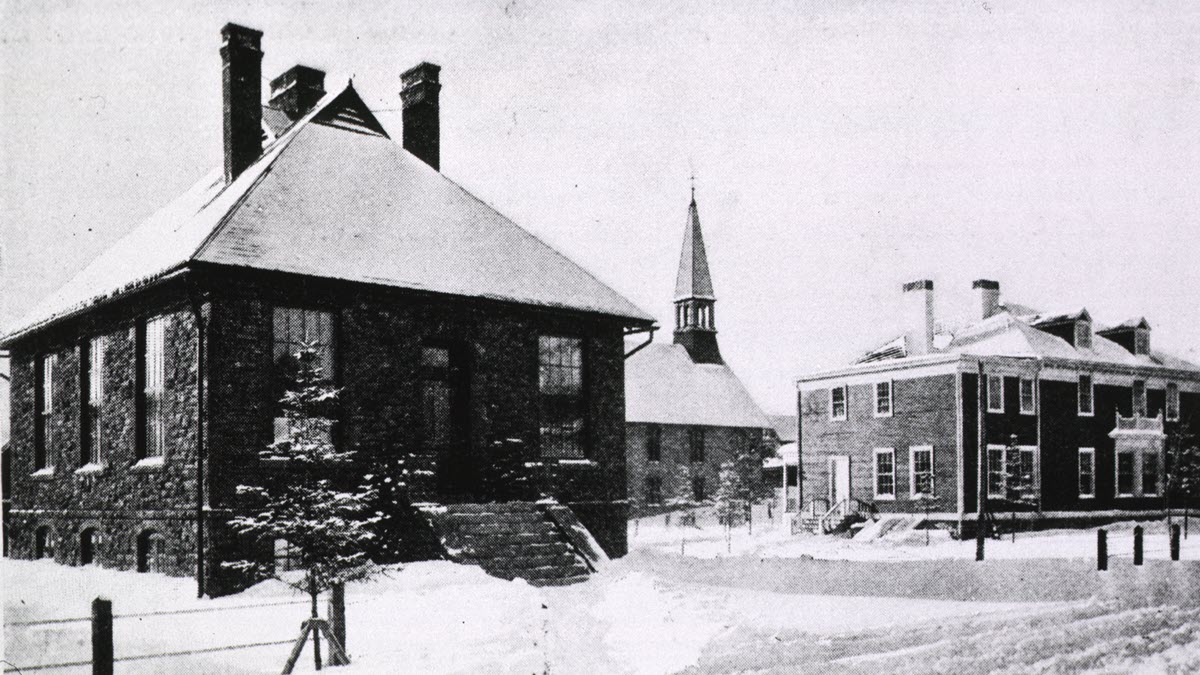 Black and white image of a TB Sanatorium with snow on the buildings and ground