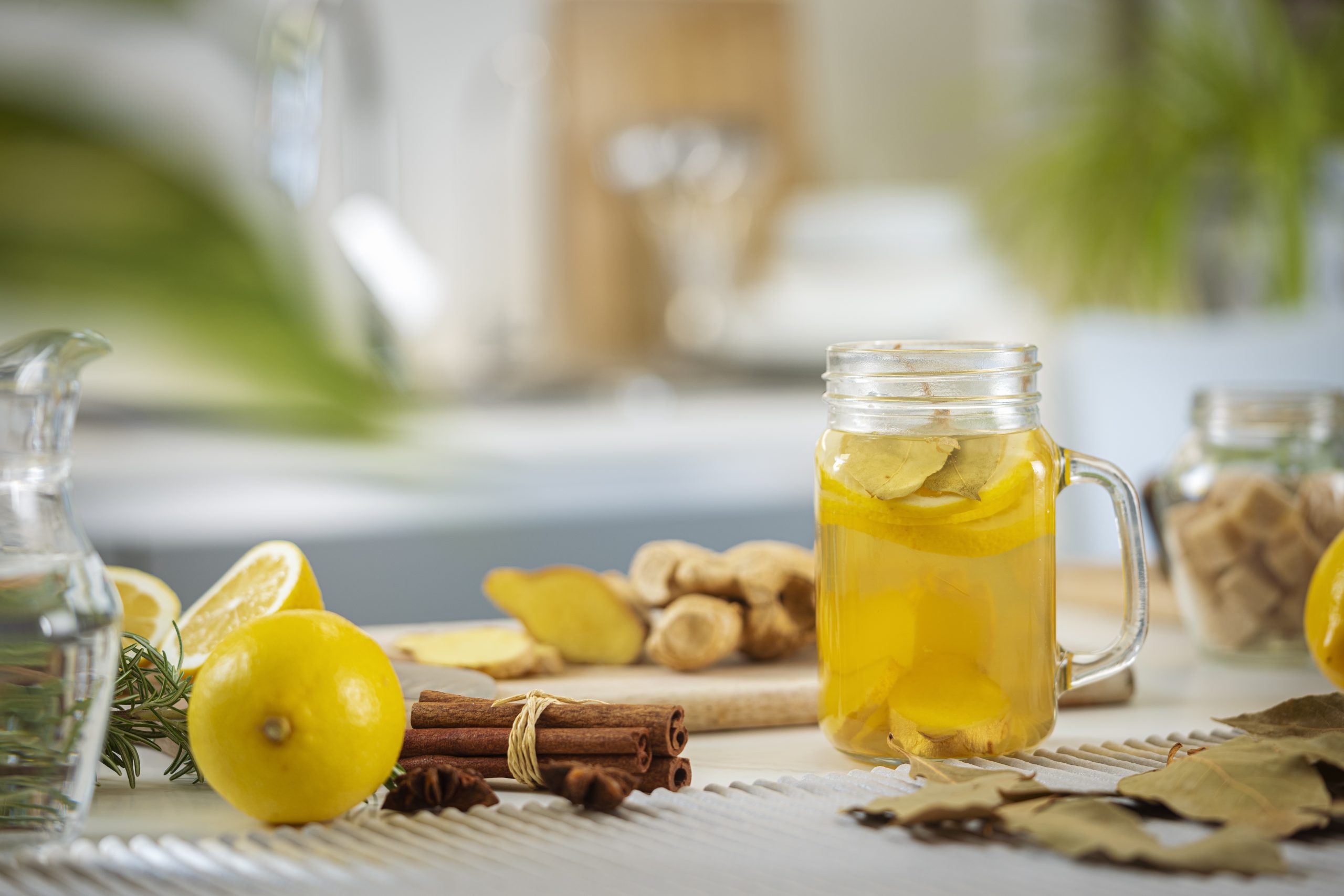 Assortment of integrative health remedies on a table such as lemon, ginger, and cinnamon sticks.