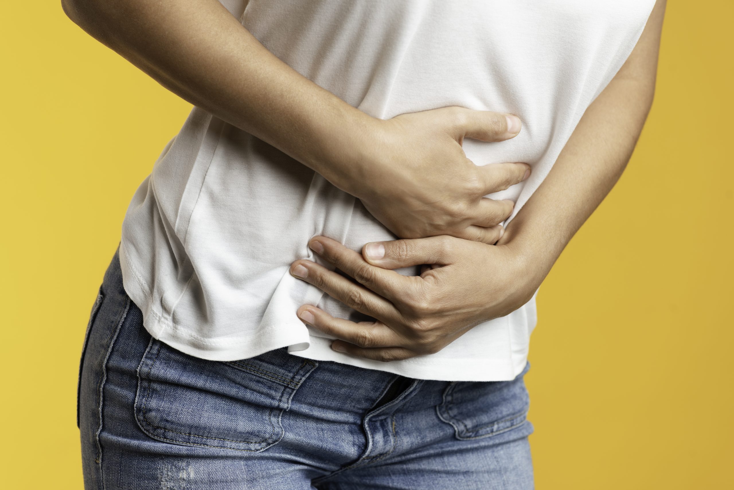 Traveler holds stomach with both hands.