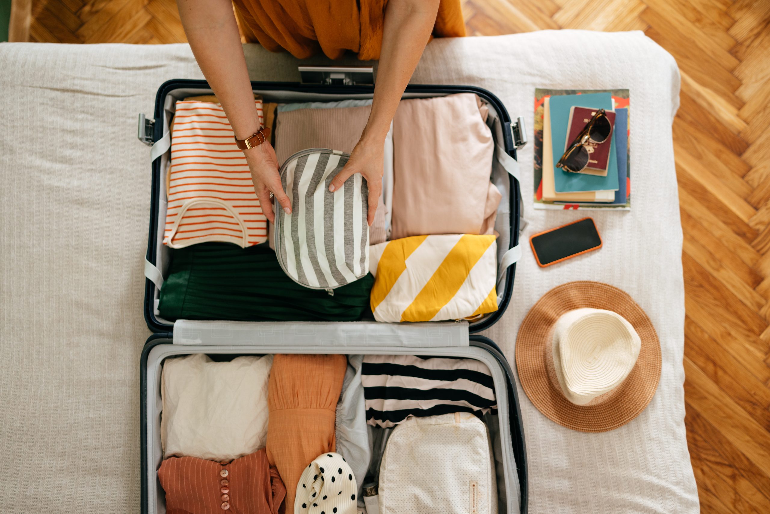 Traveler packing a suitcase.