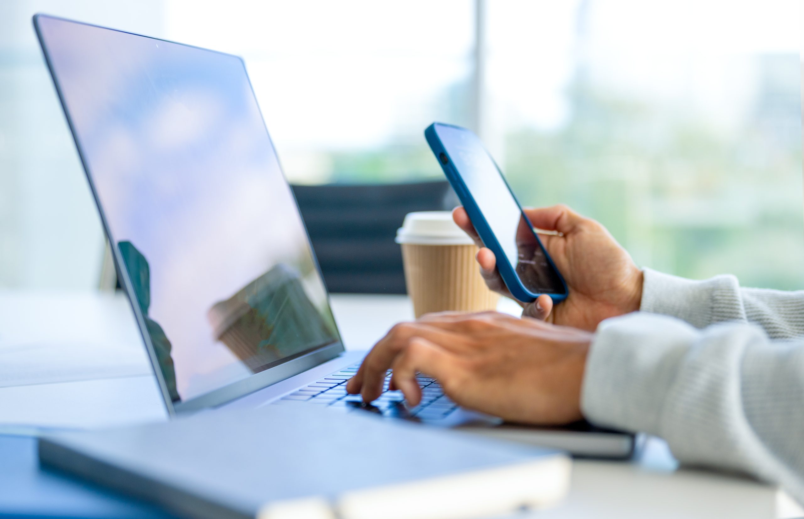 Healthcare professional looking at phone and computer.