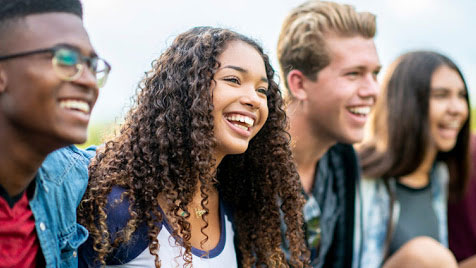 What Works in Schools Program A group of diverse teenagers laughing and smiling.