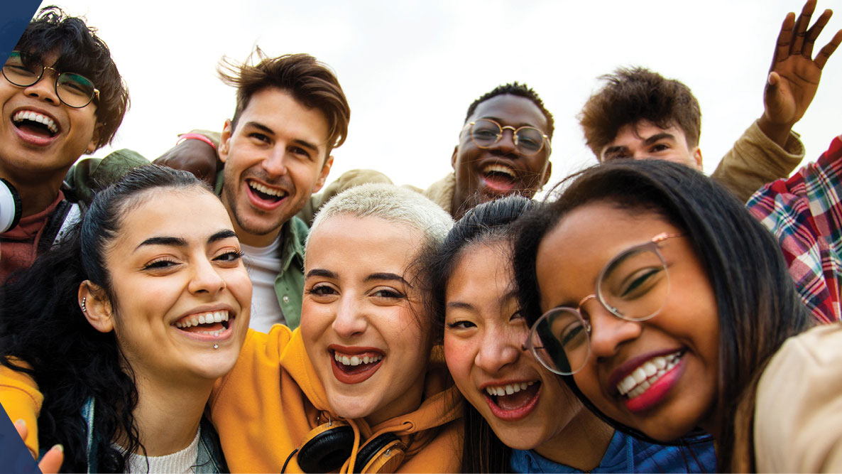 A group of multiracial teenagers, smiling and laughing.
