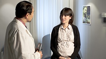 Pregnant woman with healthcare provider Pregnant woman talking with her healthcare provider
